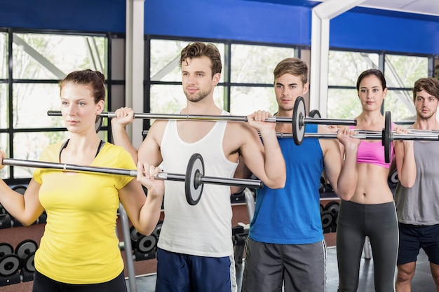 Foto clase de fitness levantando pesas en el gimnasio