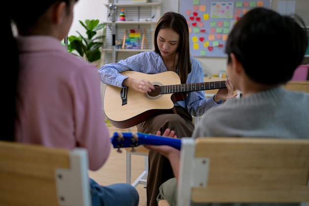 Clase de guitarra Profesora y estudiantes en la clase de música