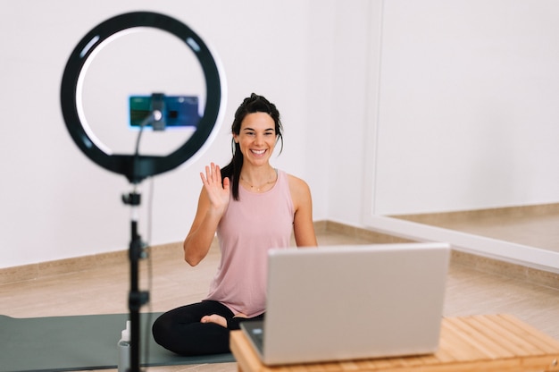 Clase en línea de profesor de yoga con teléfono y computadora portátil