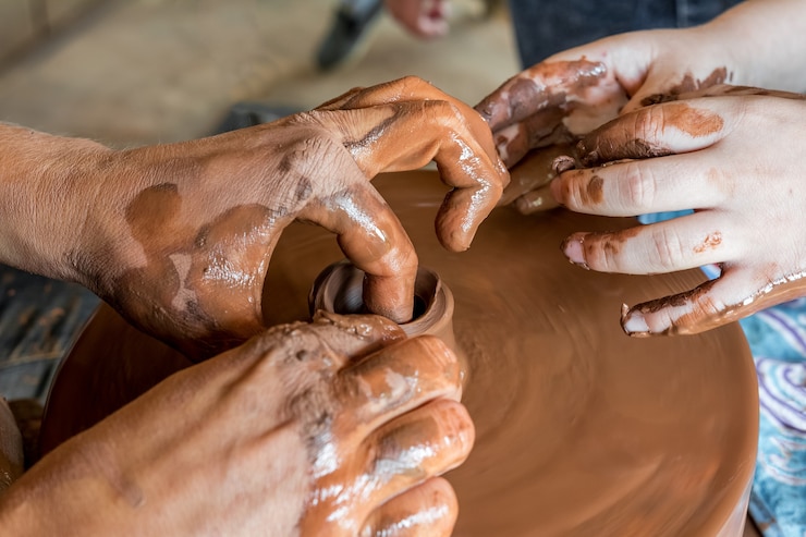 Foto clase magistral de cerámica en el festival de artesanía popular un alfarero enseña a un niño a hacer cerámica