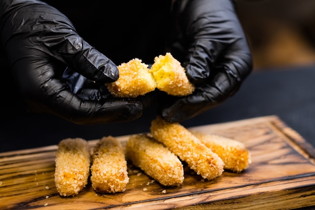 Clase magistral culinaria. Chef mostrando cómo se ven las papas fritas con polenta en pan rallado panko.