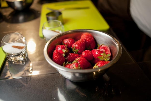 Clase magistral para niños sobre cómo cocinar galletas. Fresas en un recipiente de metal sobre la mesa