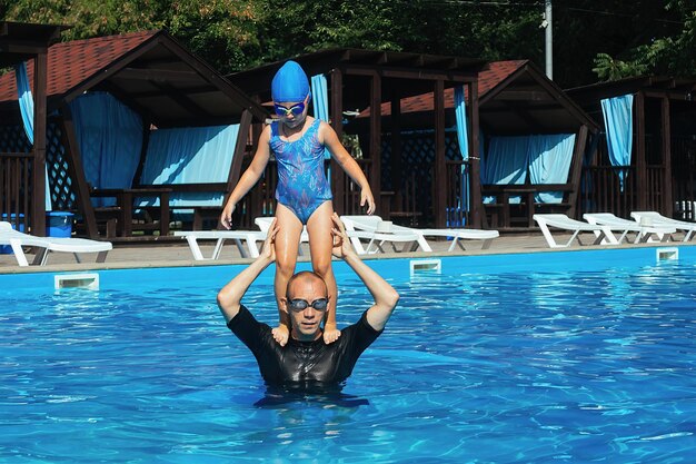 Clase de natación individual con un niño en la piscina exterior