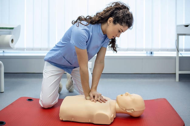 Clase de RCP con instructores hablando y demostrando compresiones de primeros auxilios y procedimiento de reanimación Maniquí de RCP