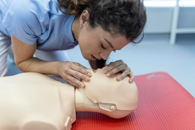 Clase de RCP con instructores hablando y demostrando compresiones de primeros auxilios y procedimiento de reanimación Maniquí de RCP