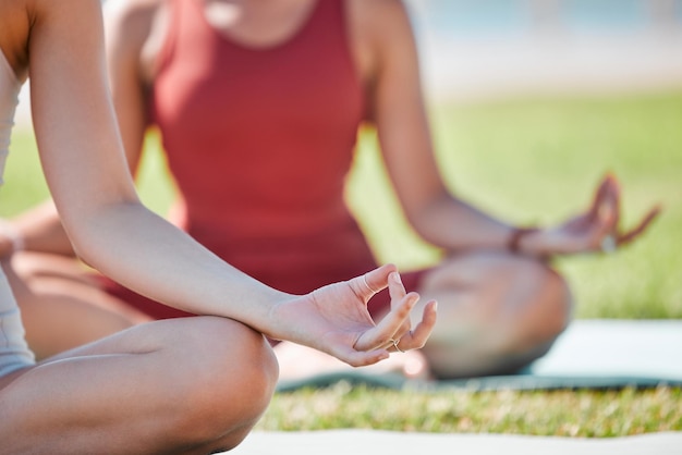 Clase de yoga manos de loto y mujeres para ejercicio de fitness zen y atención plena curación y paz en el césped del parque Meditación naturaleza y personas tranquilas entrenador personal para la salud mental y el bienestar corporal