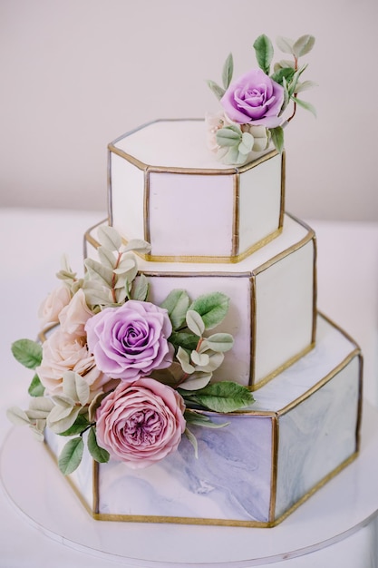 Un clásico pastel blanco y gris en niveles con decoración de flores y motivos geométricos Un pastel de bodas