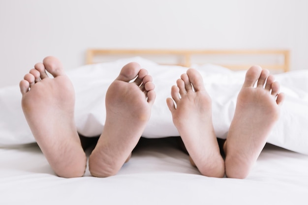 Classe baixa de pessoas relaxando na cama em casa