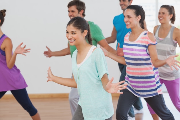 Classe de aptidão alegre e instrutor fazendo pilates