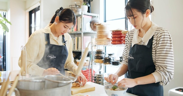 Classe de culinária restaurante e mulheres com comida japonesa em uma cozinha com chef e aprendizagem de habilidade profissional Curso de educação estudantil e culinária asiática com pessoas trabalhando juntas em habilidades