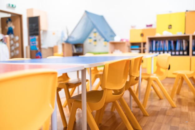 Foto classe de jardim de infância colorida sem brinquedo de cadeira de mesa de educação escolar infantil e decoração na parede de fundo infância