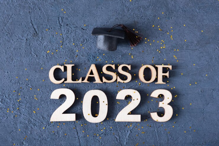 Foto classe do conceito de 2023 número de madeira 2023 com chapéu de pós-graduação em fundo escuro com ouropel