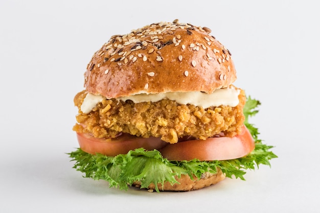 Classic Burger com frango em um pão com gergelim tomate, alface e molho de mostarda.