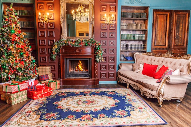 Foto clássico ano novo de natal decorado com biblioteca doméstica de quarto interior com lareira. árvore de natal com enfeites vermelhos. apartamento de design de interiores de estilo clássico moderno. véspera de natal em casa.