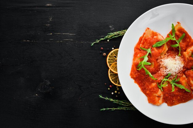 Clássico Ravioli com Molho de Tomate e Queijo Parmesão Cozinha italiana Bolinhos Em um prato sobre um fundo de madeira Vista superior Espaço para cópia grátis