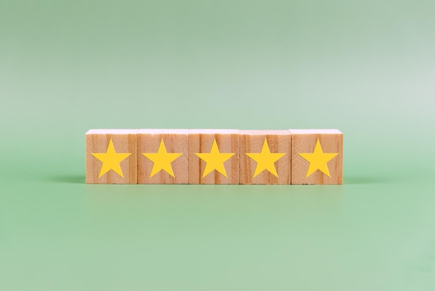 Classificação de 5 estrelas no bloco de madeira em fundo verde