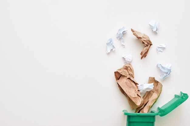 Foto classificando o conceito de lixo. foto recortada de lixo de papel. papel amassado caindo na lixeira