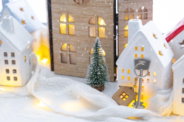 Clave y pequeña casa de un pequeño tamaño en una casa acogedora con decoración de Navidad en el alféizar de la ventana regalo