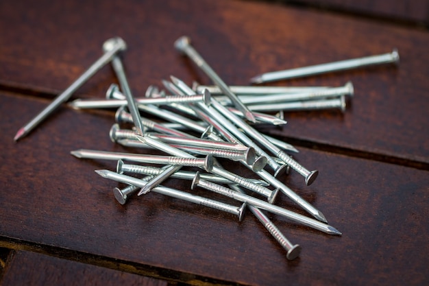 Clavos de acero en un primer plano de la mesa de madera.