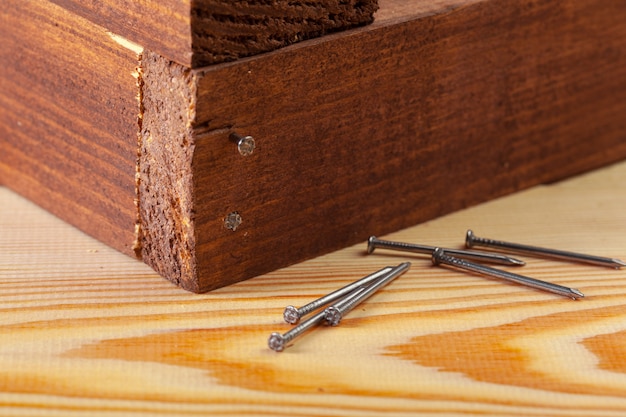 Clavos de hierro en una mesa de madera.