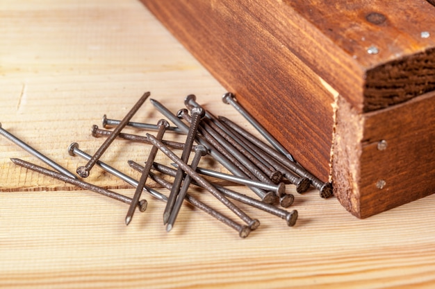 Clavos de hierro en una mesa de madera.