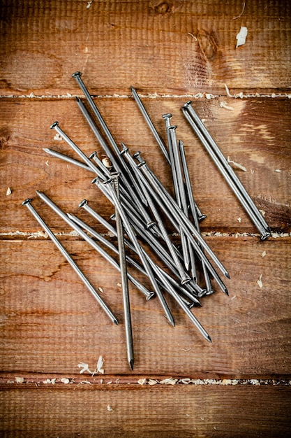 Foto clavos en la mesa sobre un fondo de madera