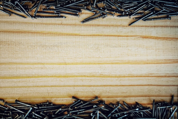 Foto los clavos pequeños están dispersos en el fondo del tablero de madera con espacio para copiar