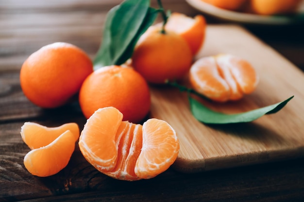 Clementinas frescas con hojas sobre la mesa de madera, cerrar