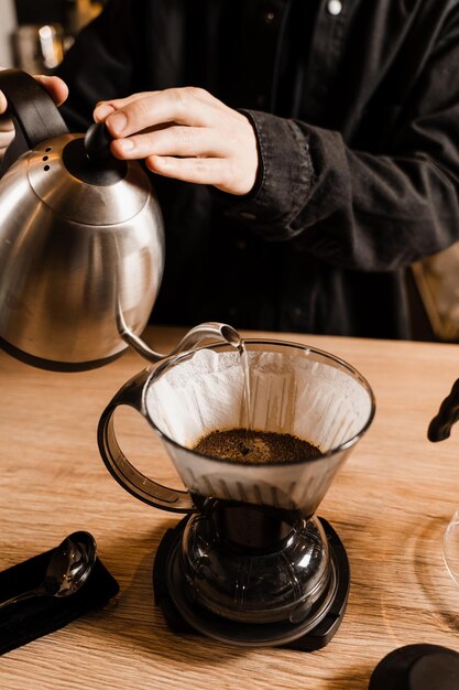 Cleverer Kaffeetropfer und alternative Brühmethode für Filterkaffee Gießen Sie heißes Wasser über geröstete und gemahlene Kaffeebohnen, die im Papierfilter enthalten sind