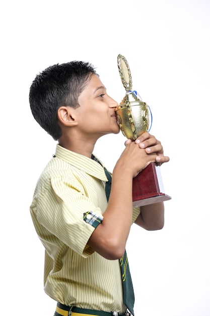 Cleverer Schüler, der seine Trophäe als Sieger im Schulwettbewerb hochhebt.