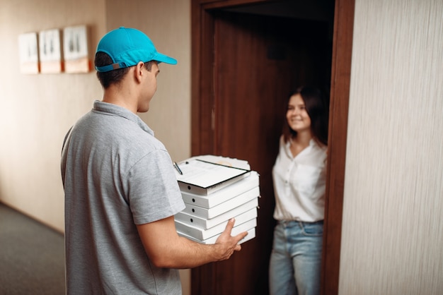 Clienta en la puerta y repartidor de pizzas