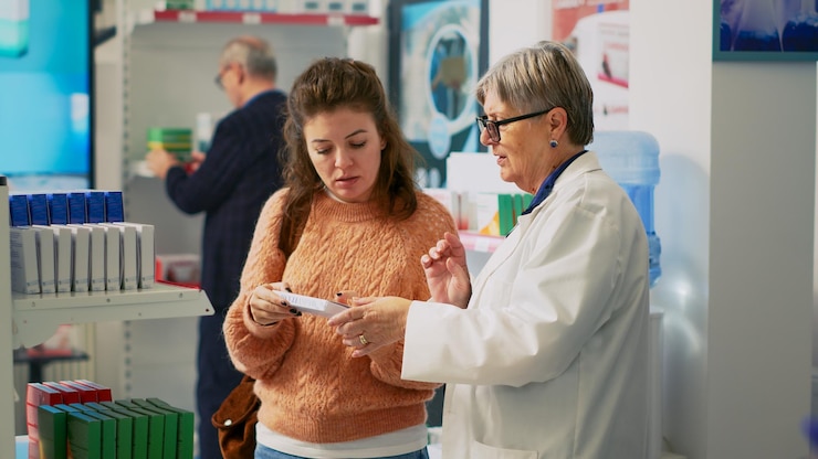 Foto clienta revisando la caja de vitaminas y hablando con el farmacéutico sobre el tratamiento, mirando el paquete de suplementos. mujer joven preguntando a un especialista en salud sobre pastillas y productos farmacéuticos.