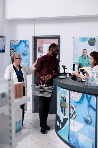 Foto cliente adulto poniendo productos farmacéuticos en el mostrador, preparándose para pagar el tratamiento. cliente afroamericano tomando cajas de medicamentos y suplementos de farmacia, servicio de medicina