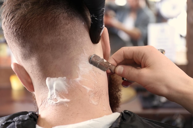 Cliente de afeitado de peluquería en barbería