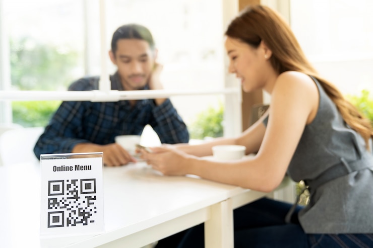 Foto cliente asiático que busca el menú en línea después de escanear el código qr. el cliente se sentó en la mesa de distanciamiento social para un nuevo estilo de vida normal en un restaurante después de la corona del virus covid-19 pamdemic.