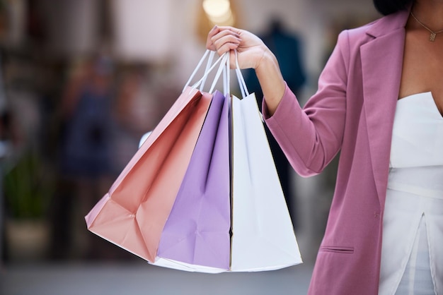 Cliente de bolsa de compras y manos de una mujer que sostiene una bolsa de papel en un centro comercial para la venta y descuento de terapia minorista Mujer de moda con compra de ropa o regalo con descuento o promoción en una tienda