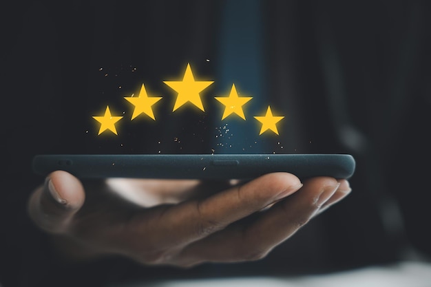 El cliente brinda comentarios positivos con una calificación de 5 estrellas en un teléfono inteligente para obtener la mejor experiencia de servicio. Encuesta de satisfacción empresarial y revisión del concepto para lograr el éxito.