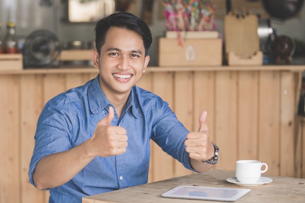 Cliente de café satisfecho mostrando el pulgar hacia arriba