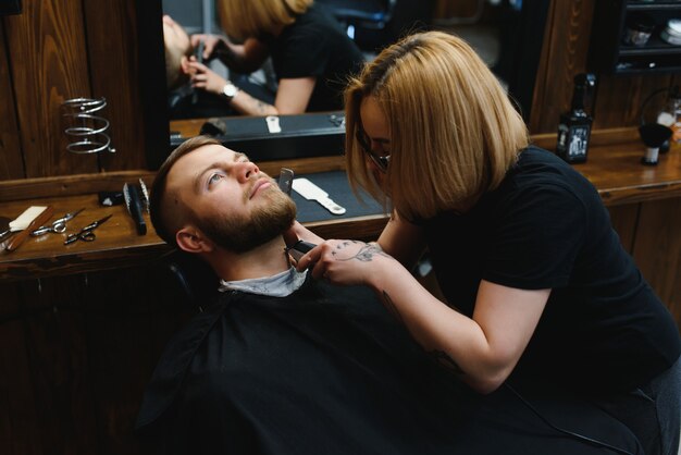 Cliente durante o barbear da barba na barbearia