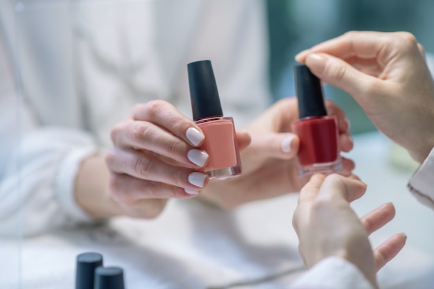 El cliente elige el color de un esmalte de uñas