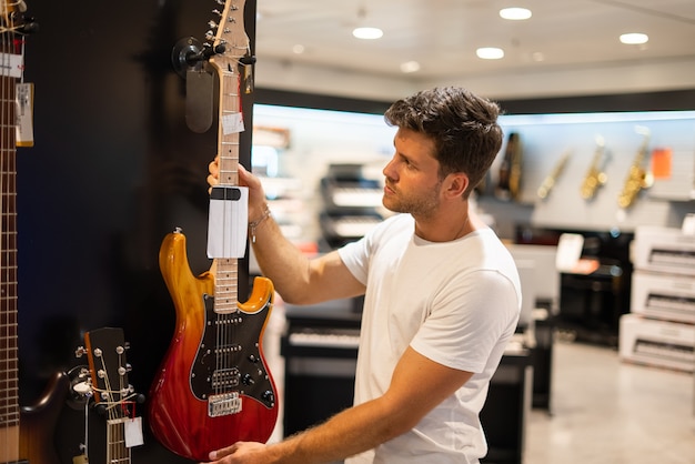 El cliente elige la guitarra en la tienda