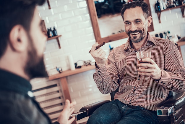 El cliente está bebiendo whisky en una peluquería