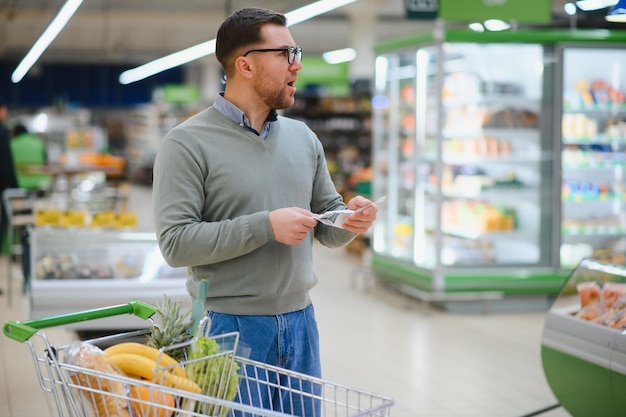 El cliente está en el supermercado decepcionado con los precios.