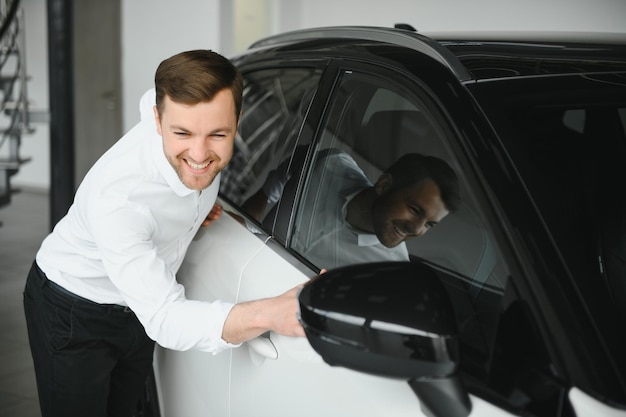 Un cliente feliz acaba de comprar un auto en un concesionario de autos