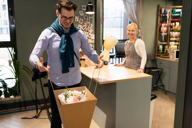 Cliente feliz com uma cesta de flores em uma floricultura