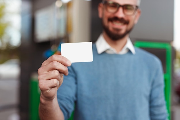 Cliente feliz demostrando tarjeta en blanco