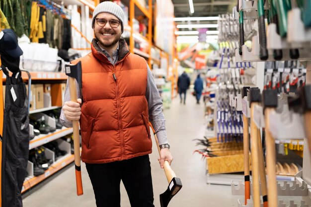 Cliente feliz em uma loja de ferragens comprando um novo machado