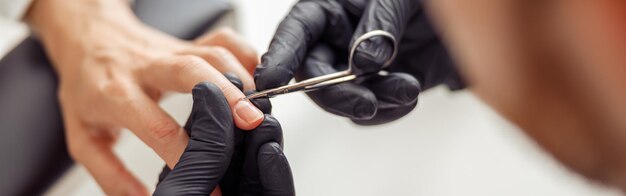 Cliente femenino recibiendo tratamiento procedimiento de manicura en el salón