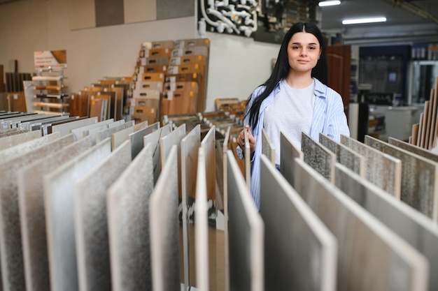 Cliente feminina escolhendo telha de cerâmica de cozinha na loja