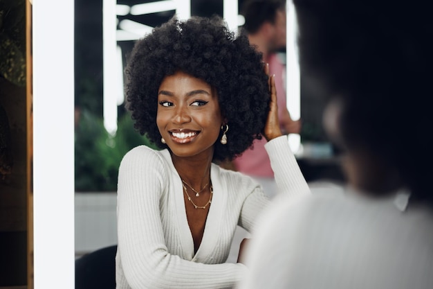 Cliente jovem africana recebendo um penteado em um salão de beleza